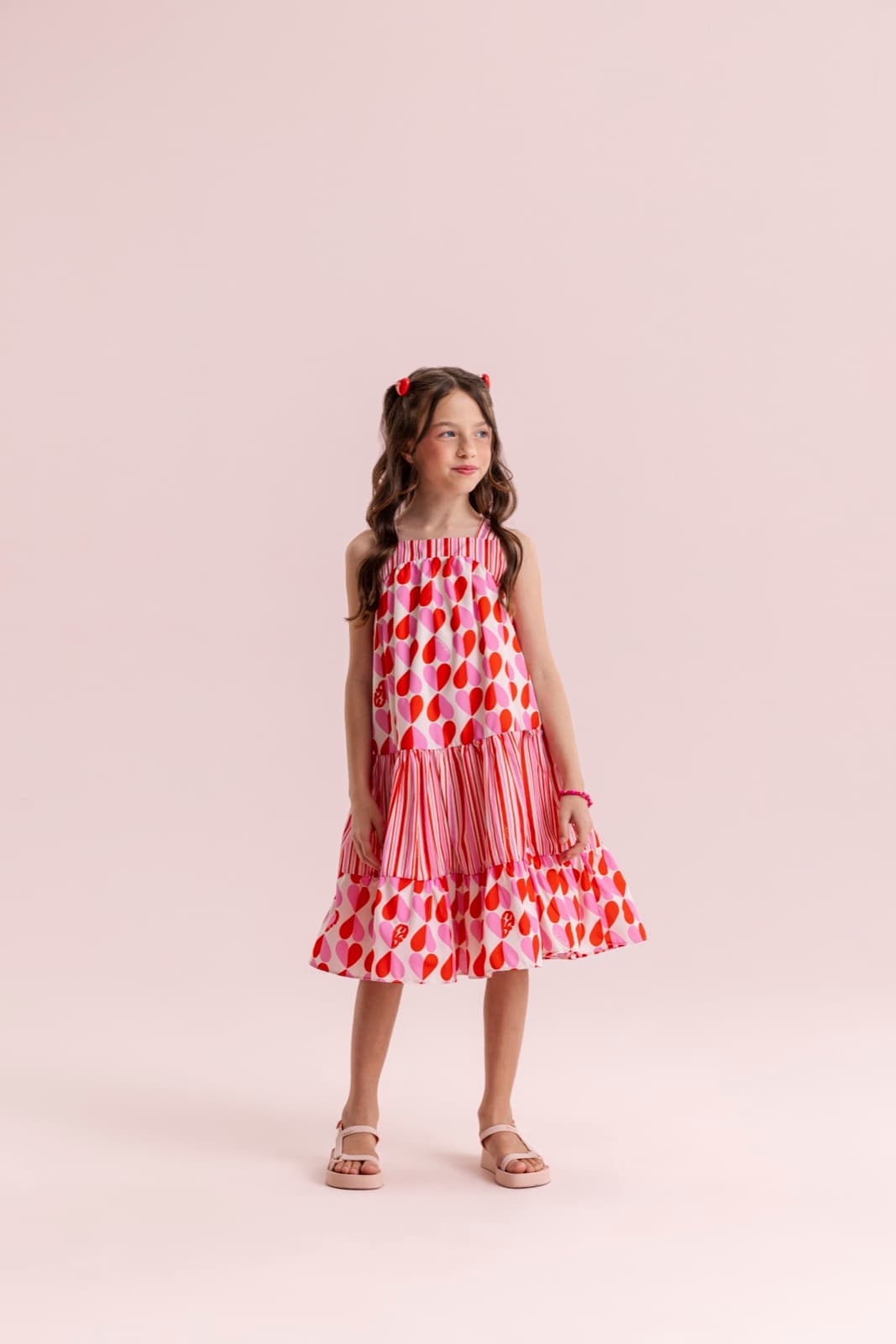 Menina usando vestido estampado em rosa e vermelho