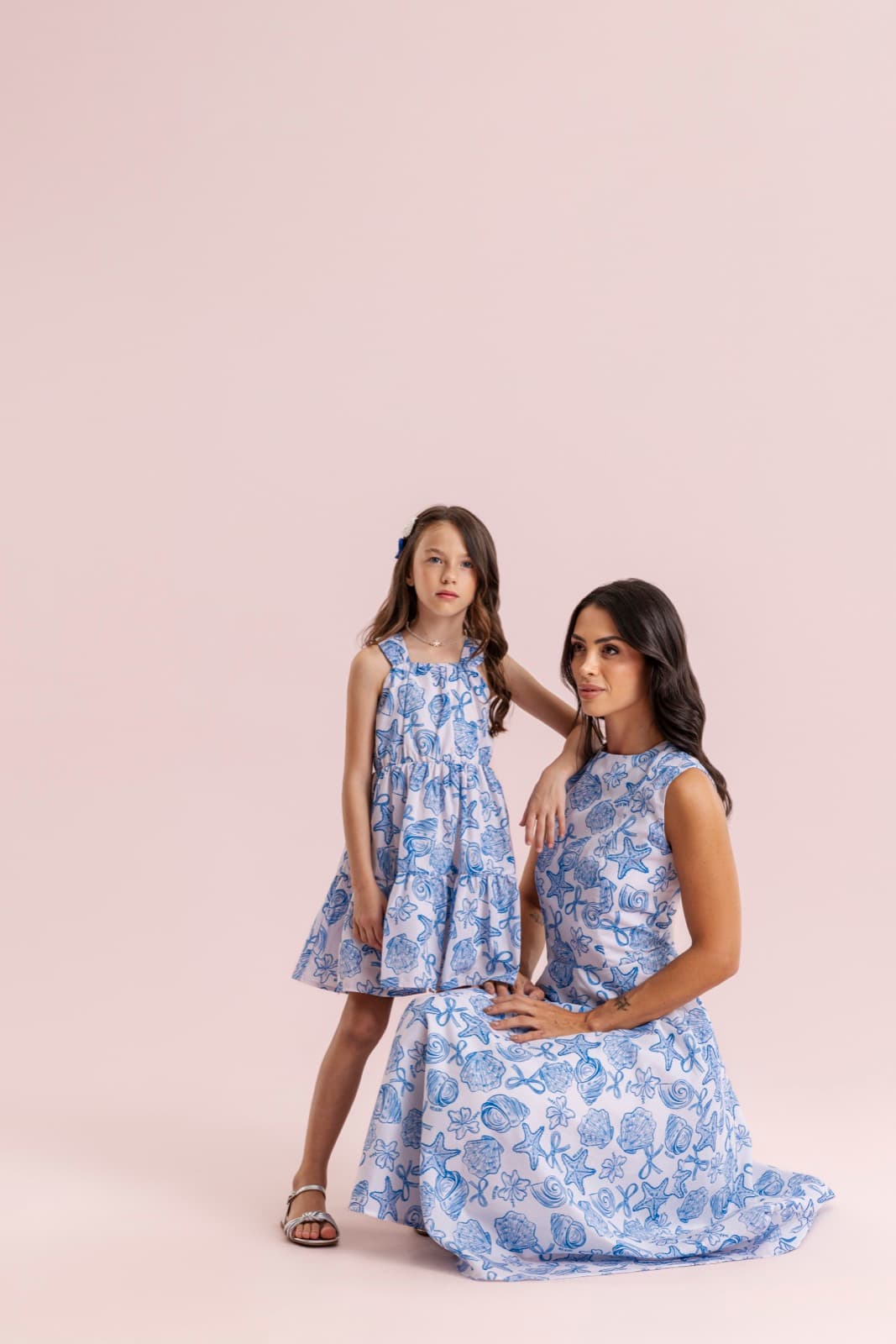 Mãe e filha juntas usando vestidos coordenados em azul e branco