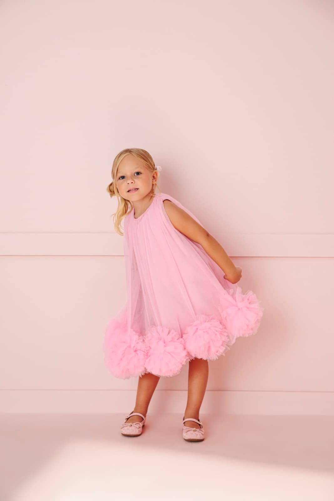 Menina pequena brincando com vestido de tule rosa